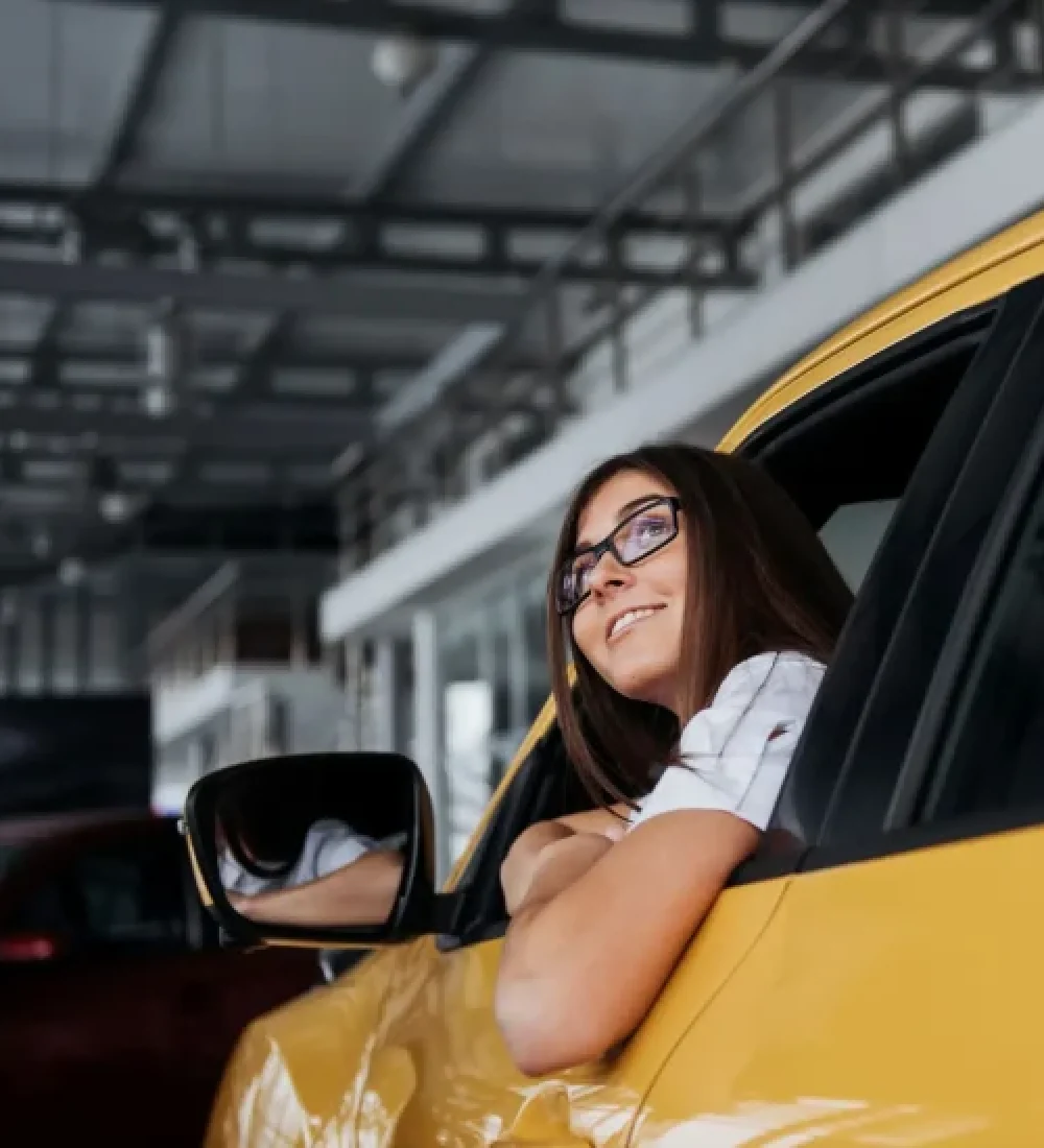 smiling-woman-inside-a-yellow-car-looking-up-2026-01-09-00-39-43-utc-rof2zgkau290zfo7ky440f7091eygqaafe7anfdsak